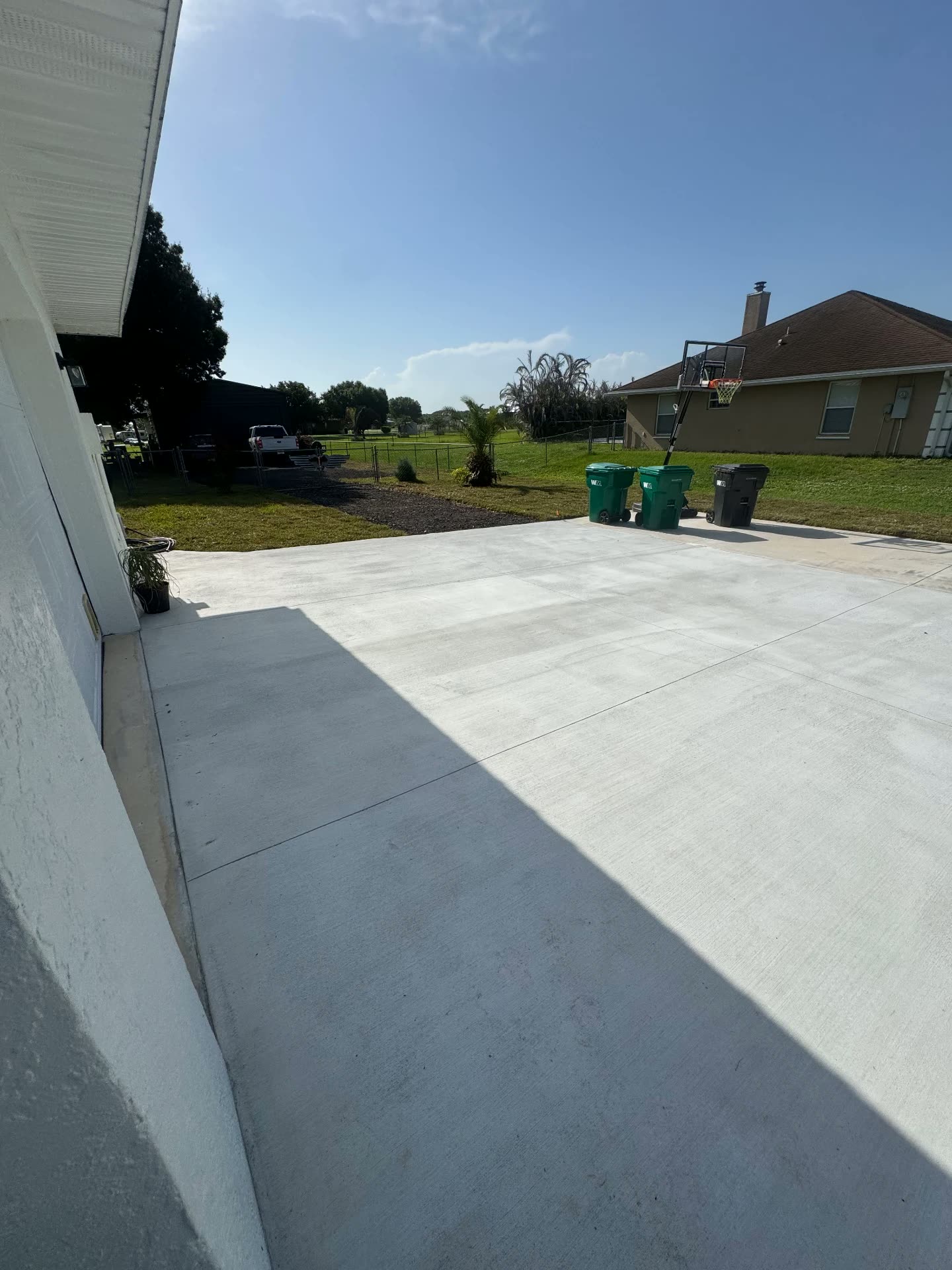 Freshly poured concrete driveway extension with clean control joints