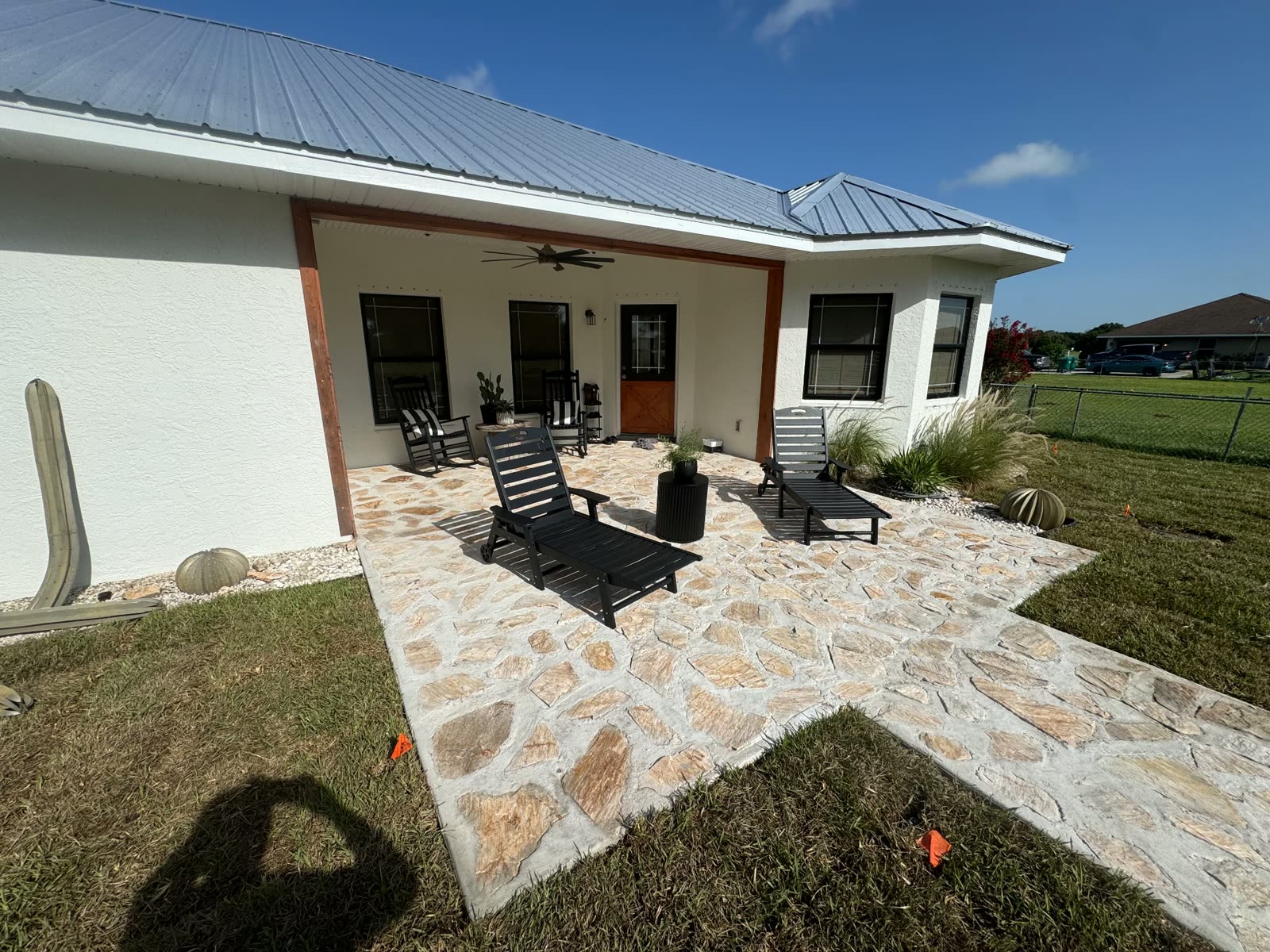 Stone-textured concrete patio and walkway wrapping a covered porch