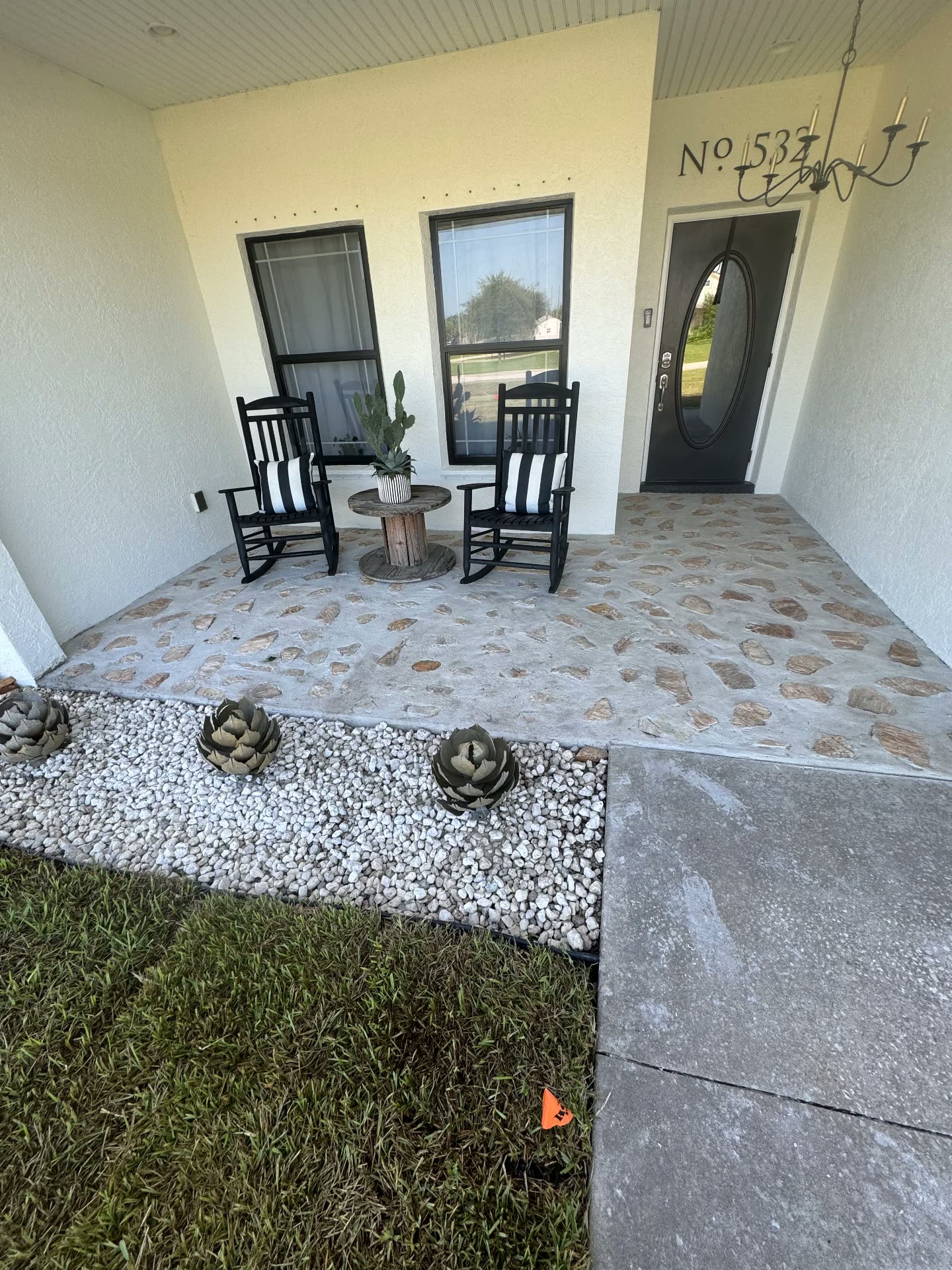 Decorative stone-finish concrete front porch with rock border